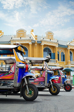 Colorful Tuk Tuk Taxis Parked in Front of Yellow Colonial Building in Bangkok Thailand
