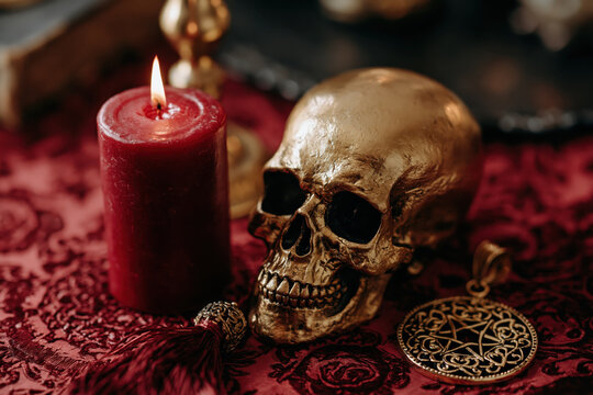 Red candle golden skull occult decor dark ritual gothic still life with flame velvet cloth amulet shadow bone motif mysterious mood