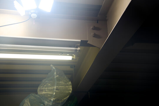 LED and Fluorescent Lights Under Steel Beam Garage Ceiling