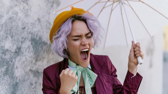 Young woman with purple hair yelling under umbrella urban fashion portrait for editorial background and dramatic expression