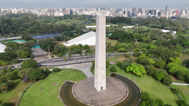 Centered aerial view of the Obelisk of Sao Paulo featuring the white Oca dome and the metropolis skyline in Brazil.
