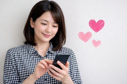 スマートフォンを見つめて微笑む女性がハートで共感と好意を伝えるコミュニケーションシーン