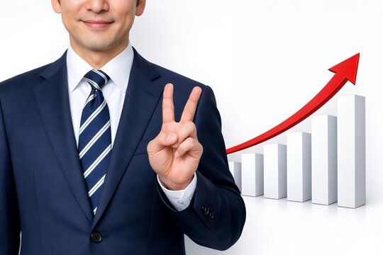 スーツ姿のビジネスマンがVサインで成長を示す上昇グラフと成功をアピールする場面