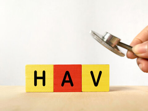Wooden blocks spelling HAV beside a stethoscope, representing hepatitis A virus, viral infection, liver disease, medical diagnosis and healthcare awareness.