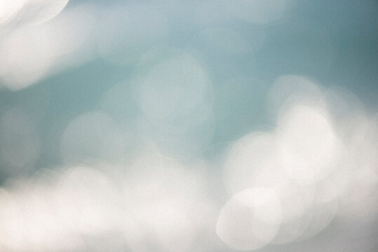 A dreamy blue background with soft bokeh lights, subtle grain, tiny dust particles. The vintage texture gives it a nostalgic, cinematic feel, perfect for adding atmosphere to creative designs.
