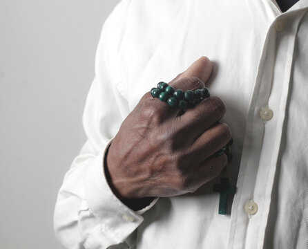 praying to god with hands showing his religious faith with God Caribbean man praying with background with people stock photo stock image	