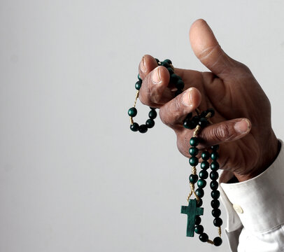 praying to god with hands showing his religious faith with God Caribbean man praying with background with people stock photo stock image	