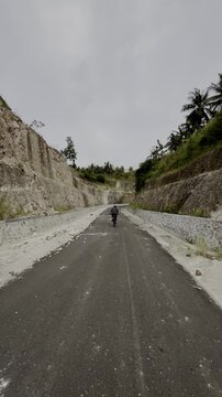 Cyclist Riding on Rural Mountain Road