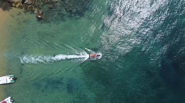Drone footage of a jet ski riding through the clear waters of Skiathos.