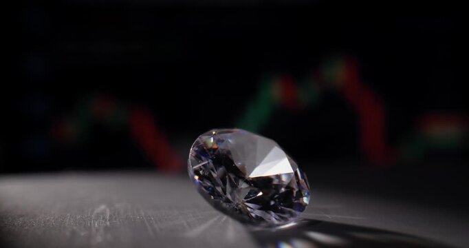 Diamond rolling on tabletop with financial chart background probe lens.