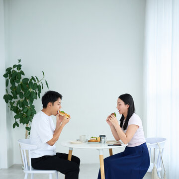 Young Japanese Man and Woman Enjoying Light Meal Together at Table