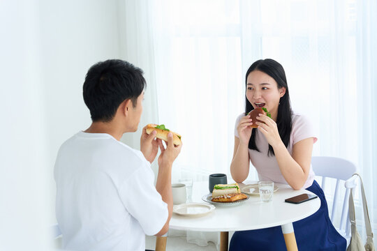 Young Japanese Man and Woman Enjoying Light Meal Together at Table