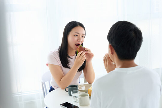 Young Japanese Man and Woman Enjoying Light Meal Together at Table