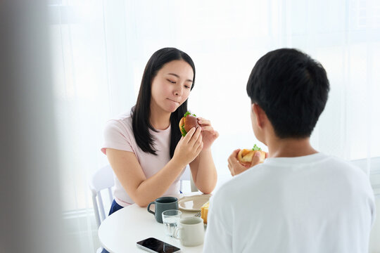 Young Japanese Man and Woman Enjoying Light Meal Together at Table