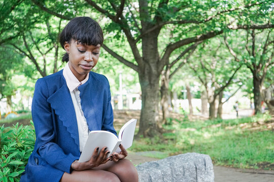 公園で読書をする黒人女性