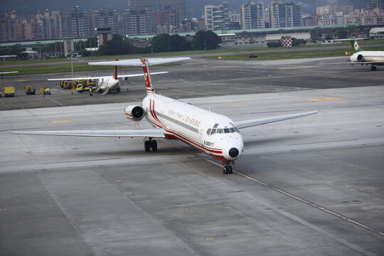 A commercial passenger airplane taxis on the airport runway during operations.