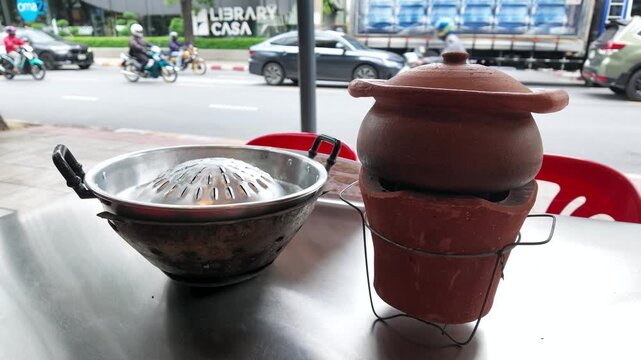 Traditional Thai Mookata Grill and Clay Pot on Outdoor Table