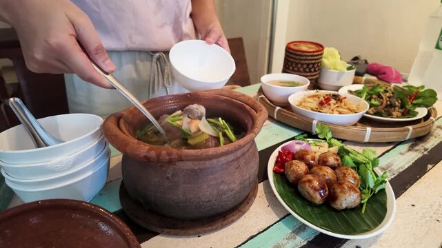 Serving Hot Thai Soup from Traditional Clay Pot in Bangkok
