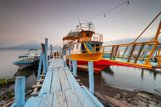 Colorful fishing boats at a lakeside pier