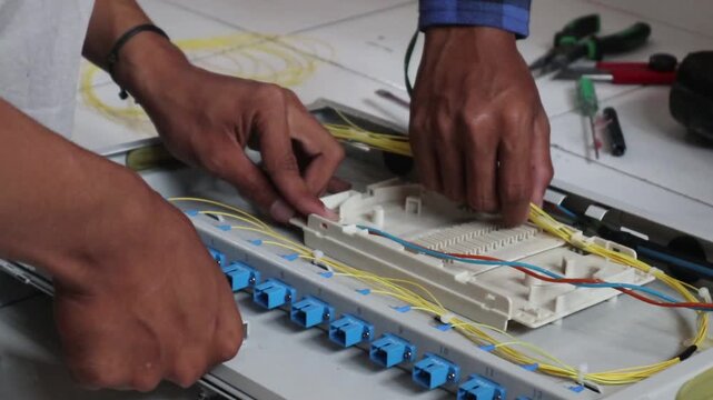 Technicians install fiber optic cables