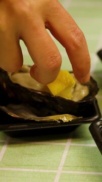 Hand Squeezing Fresh Lemon Juice onto Raw Oyster in Tokyo