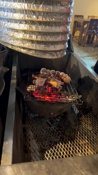 Grilled Chicken and Sausages Cooking on Charcoal Grill in Bangkok