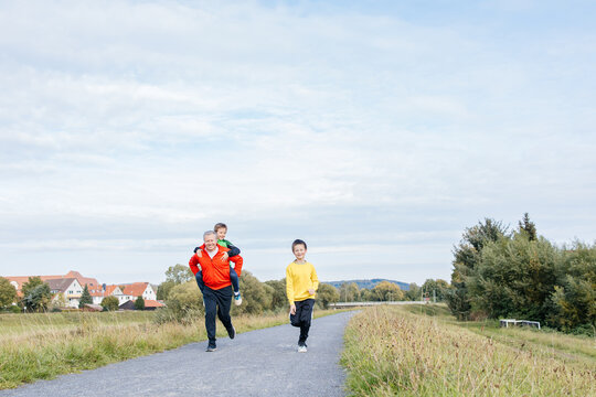 Father and sons enjoying outdoor exercise on a path
