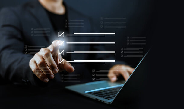 Businessman hand pointing at virtual screen with checklist and task completion interface. Concept of project management, digital workflow, task automation, and corporate business efficiency.