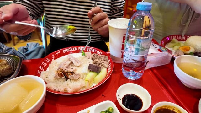 Person Eating Thai Hainanese Chicken Rice at Street Food Stall