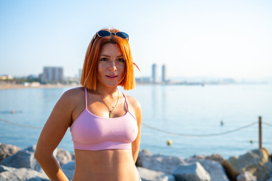 Woman with red hair standing on Barcelona beach