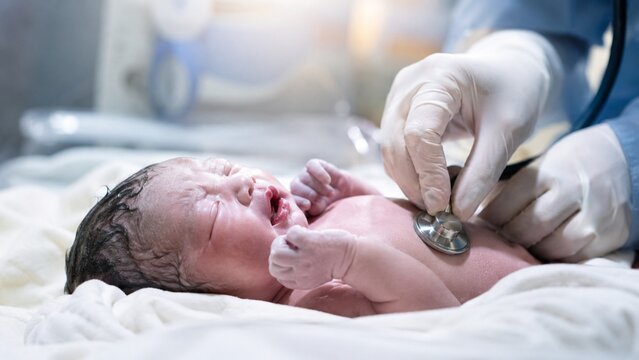 Doctor examining a newborn baby with a stethoscope