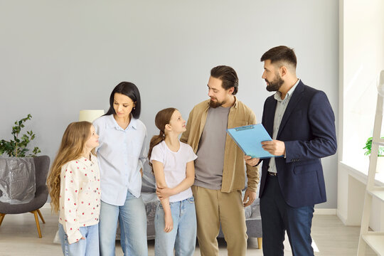 Family children realtor consultation in home interior. Parents and agent hold discussion, review purchase contract in bright empty living room. Positive real estate family consultation concept