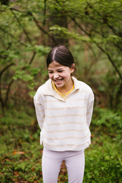 Young girl laughing happily in a lush forest