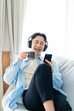 コーヒーを飲みながらスマートフォンを使う男性