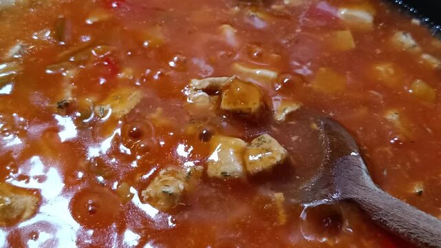 morceaux de thon en cuisson dans une sauce tomates et l&eacute;gumes