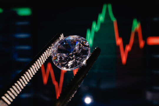 Diamond held by tweezers over fluctuating financial investment chart display