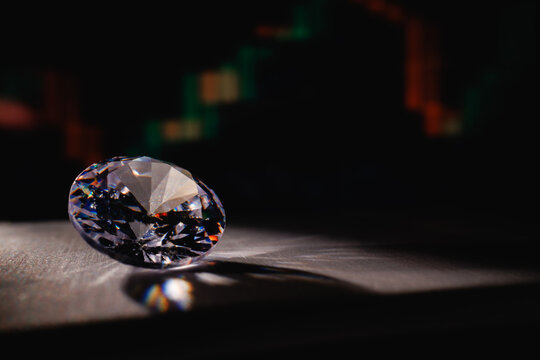 Diamond resting on surface with chart business investment background