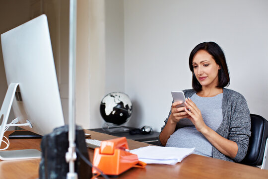 Phone, remote work and typing with pregnant woman in home office for planning or research. App, pregnancy and small business with freelance employee at desk in apartment for maternity preparation