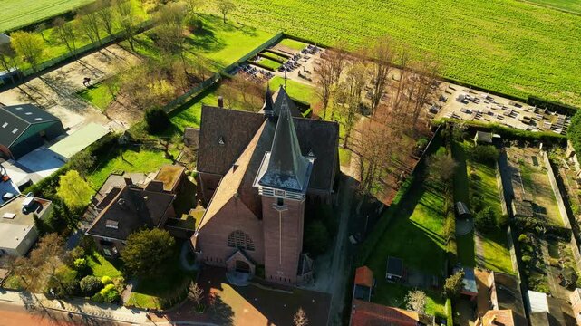 Orbiting aerial footage of a church in Flanders
