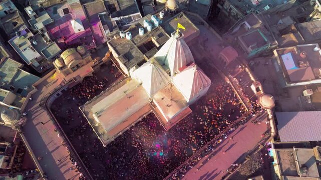 Overhead Aerial View of Nand Baba Temple and Nandgaon During Holi Showing Multicolored Gulal in the Air, Crowded Temple Area and Traditional Braj Architecture