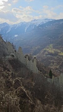 Vertical shot of the unique Pyramides dEuseigne earth pyramids in the Swiss Alps. These natural rock formations are a geological wonder in the Canton of Valais, surrounded by snowcapped peaks.