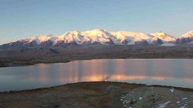 Aerial view of sunrise and golden snow mountain at Karakul Lake and Kongur Tiube Peak in Xinjiang China
