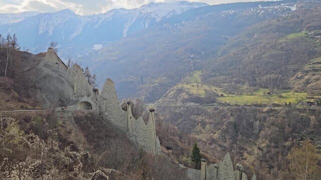 Pyramides d&rsquo;Euseigne in Valais, Switzerland, featuring remarkable fairy chimney rock formations surrounded by an alpine valley and dramatic mountain scenery, aerial