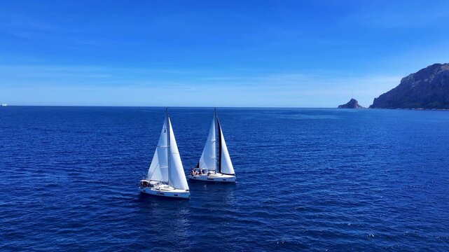 Aerial view of sailboats in turquoise sea at Tavolara island, Sardinia, Italy