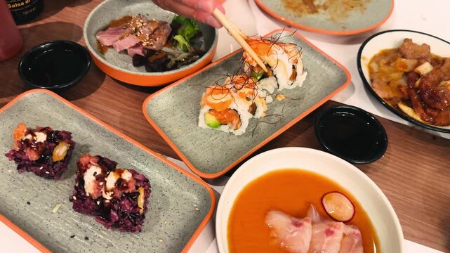 Shiromi, sushi, rolls and sashimi are beautifully arranged on a table at an Asian buffet restaurant.