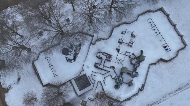 Top down aerial footage of a frozen playground after heavy snowfall