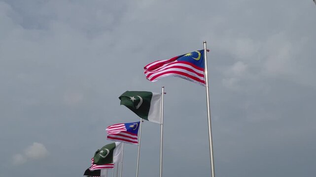 Pakistan and Malaysia National Flags Waving Together Under Cloudy Sky, International Relations, Seamless Loop