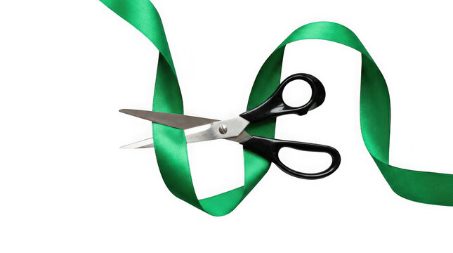 Pair of black scissors cutting a green silk ribbon isolated on transparent background