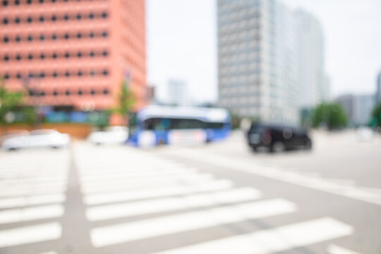 Abstract blurred modern downtown Seoul wide avenue background with a blue transit bus and crosswalk