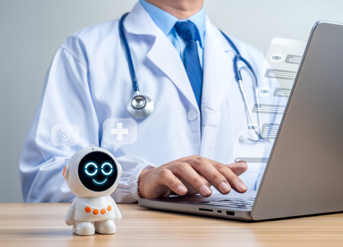 Friendly robot assistant beside a doctor chat with chatbot on laptop. AI-powered patient support, digital consultations, automated healthcare communication, and virtual medical services concept.